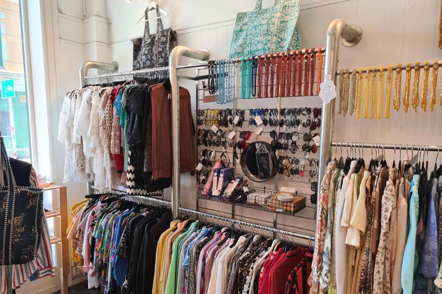 Klær på stativ og tilbehør på vegg hos Lykka på Løkka