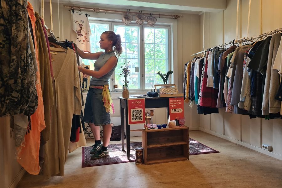 Ansatt hos Hidden Gem som ordner klær i butikken