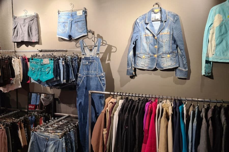 denim på vegg og stativ med klær hos vintage kid oslo på helsfyr