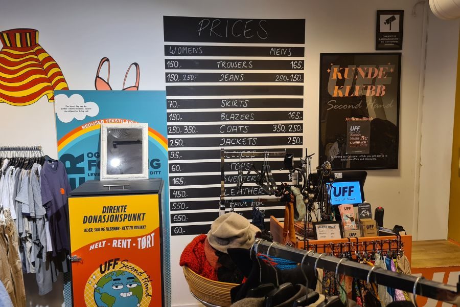 Disken med tavle som viser priser på secondhand klær hos UFF Brugata