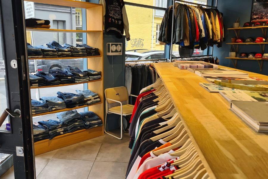 Stativ med drakter og t-skjorter og jeans på hyller hos Ditto på Majorstua