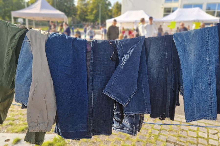 Flere jeans hengende på en snor på loppisen til Hasle skole