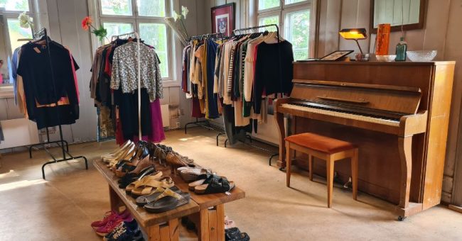 Lokalene til Hidden Gem med piano og stativer med klær