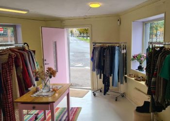Lokalet til The Skandi Edit på Kampen med vintageklær på stativer, gule vegger og rosa dør