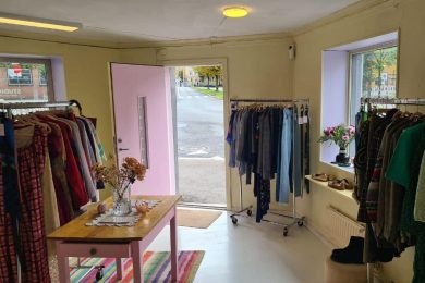 Lokalet til The Skandi Edit på Kampen med vintageklær på stativer, gule vegger og rosa dør