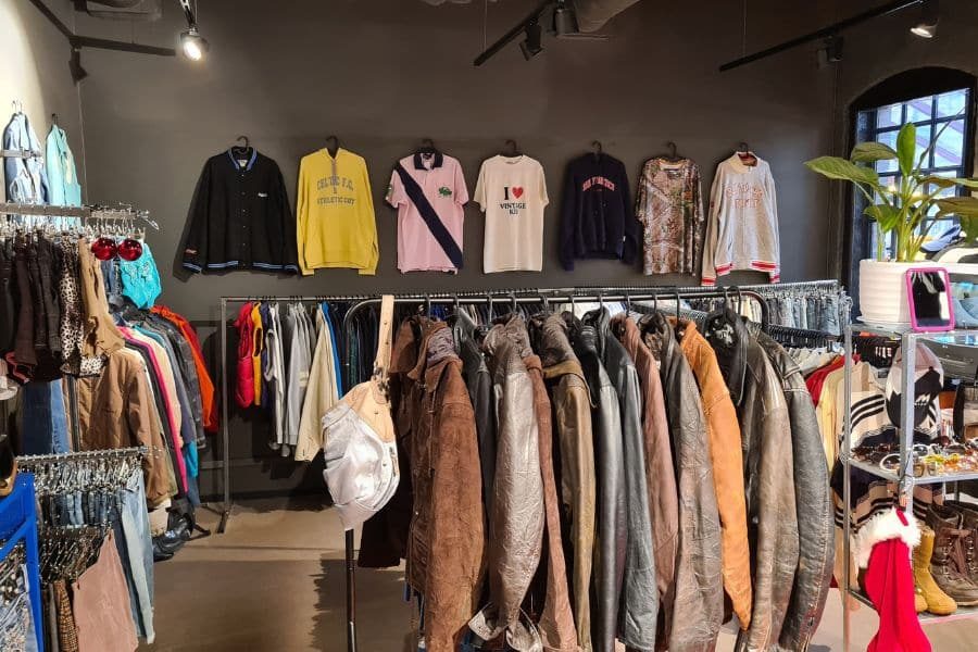 Lokalene hos Vintage Kid Oslo fylt med vintageklær på stativ og vegger