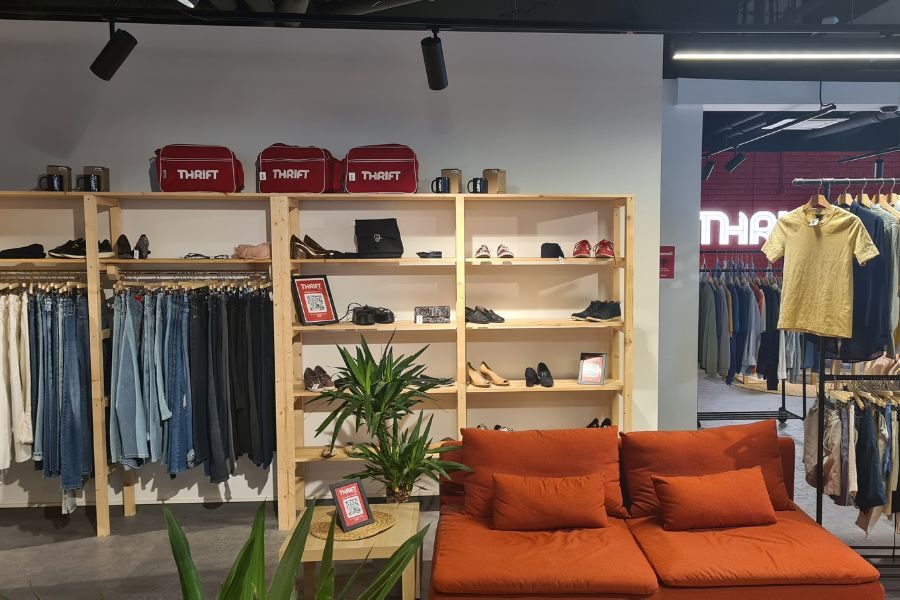 Sofagruppe og hyller med sko, busker og vesker hos Thrift Tøyen