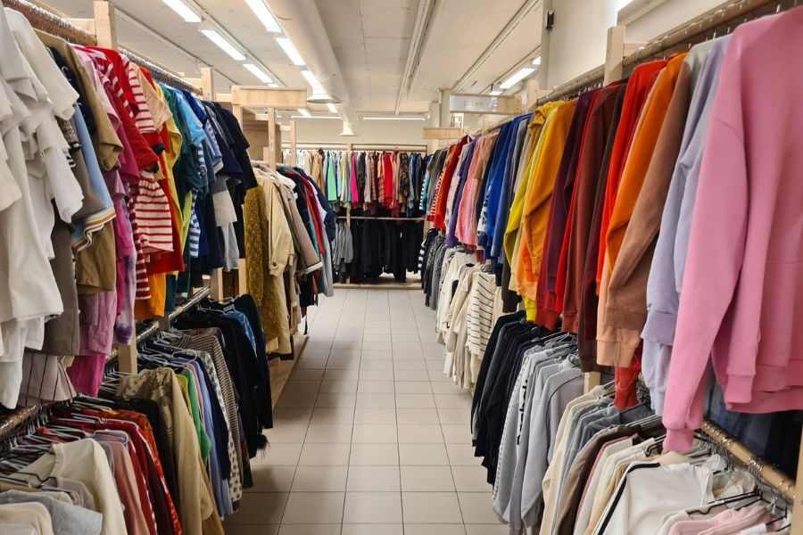 Tett i tett med klær på stativer hos Det Gule Hus Flagship
