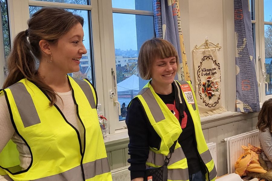 To frivillige i gule vester åp loppemarkedet på Kampen skole