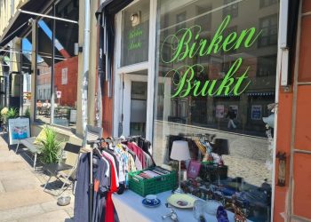 Utenfor inngangen til Birken Brukt på Grunerløkka med klesstativ og et bord med ting og tang