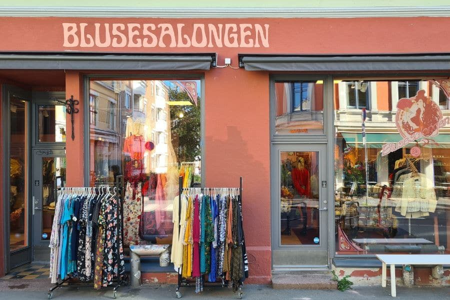 Utenfor lokalene til Blusesalongen på Grunerløkka med rosa vegg og klesstativ