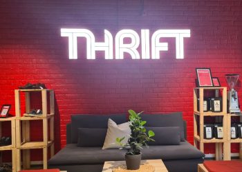 Detaljvegg hos Thrift Tøyen med lysende THRIFT på veggen