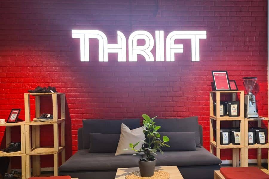 Detaljvegg hos Thrift Tøyen med lysende THRIFT på veggen