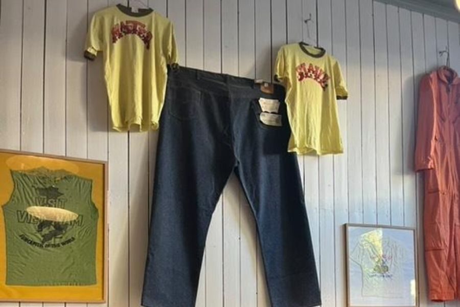 En stor jeans og to t-skjorter pryder veggen hos Solitude Vintage på Frogner